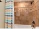 Tiled bathroom featuring a shower with rainfall showerhead, and neutral-colored tiles at 479 Blue Lake Trl, Lafayette, CO 80026