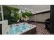 Inviting hot tub on a wooden deck under a pergola, surrounded by lush greenery at 479 Blue Lake Trl, Lafayette, CO 80026