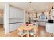 Charming eat-in kitchen features white cabinets, granite counters, stainless appliances, and decorative pendant lighting at 479 Blue Lake Trl, Lafayette, CO 80026