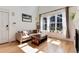 Sun-drenched living room featuring hardwood floors, a cozy sofa, and bright windows at 479 Blue Lake Trl, Lafayette, CO 80026