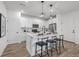 Modern kitchen features a center island with seating, sleek white cabinets, and stainless steel appliances at 13860 Ash Cir, Thornton, CO 80602