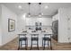 Bright kitchen features a center island with seating, modern pendant lighting, and stainless steel appliances at 13860 Ash Cir, Thornton, CO 80602
