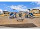 Community playground with slides, climbing ropes, and seating areas surrounded by well-maintained homes at 13860 Ash Cir, Thornton, CO 80602