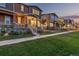 Charming homes with inviting front porches and manicured lawns, illuminated by warm exterior lighting at dusk at 13860 Ash Cir, Thornton, CO 80602