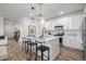 Modern white kitchen with stainless steel appliances, an island, and stylish pendant lights at 13860 Ash Cir, Thornton, CO 80602