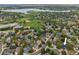 Aerial view of a neighborhood with a lake, park, and houses with mature trees at 18056 E Bellewood Dr, Aurora, CO 80015