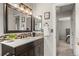 Bathroom featuring a large, framed mirror over a dark vanity, providing style and functionality at 18056 E Bellewood Dr, Aurora, CO 80015
