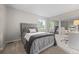Bedroom showcases tufted headboard, neutral carpet, large windows, and a mirrored closet for added appeal at 18056 E Bellewood Dr, Aurora, CO 80015