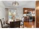 Warm and inviting dining area with wood floors and cabinets, with sliding glass door to the backyard at 18056 E Bellewood Dr, Aurora, CO 80015