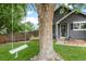 View of the front yard with a mature tree and a white tree swing in front of the house at 18056 E Bellewood Dr, Aurora, CO 80015