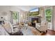 Cozy living room featuring hardwood floors, a stone fireplace, and ample natural light at 18056 E Bellewood Dr, Aurora, CO 80015