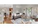Well-lit living room showcasing hardwood floors, a modern rug, and an open layout to the dining area at 18056 E Bellewood Dr, Aurora, CO 80015