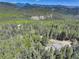 High-altitude aerial view reveals property surrounded by verdant forests and rolling mountain landscapes at 8340 London Ln, Conifer, CO 80433