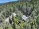 Scenic aerial view of a house surrounded by dense forest, providing privacy and stunning natural views at 8340 London Ln, Conifer, CO 80433