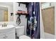 Cozy bathroom featuring a toilet, tub with Star Wars shower curtain, sink, and rustic shelves at 8340 London Ln, Conifer, CO 80433