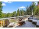 Outdoor deck with patio furniture, offering forest views for relaxing or entertaining guests at 8340 London Ln, Conifer, CO 80433