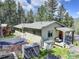 Charming exterior view featuring a swing set, trampoline, covered porch with seating, and wooded surroundings at 8340 London Ln, Conifer, CO 80433