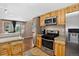 Bright kitchen featuring wooden cabinets, granite countertops, and stainless steel appliances at 8340 London Ln, Conifer, CO 80433