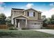 Two-story house with beige siding, stone accents, and a two-car garage at 9353 Yampa Ct, Commerce City, CO 80022