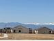 New single-Gathering homes with mountain views in the distance and a sidewalk in the foreground on a sunny day at 9353 Yampa Ct, Commerce City, CO 80022