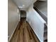 Light-filled hallway with wood-look floors leading to living areas and staircase at 9353 Yampa Ct, Commerce City, CO 80022