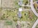 A bird's-eye view highlights a home with a long driveway, fenced yard, and established landscaping in a serene setting at 34101 Columbine E Trl, Elizabeth, CO 80107