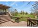 Wooden deck, with stairs descending to a lush lawn and backyard play area at 34101 Columbine E Trl, Elizabeth, CO 80107
