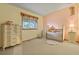 Bedroom with a crib, dresser, and large window offering ample natural light at 34101 Columbine E Trl, Elizabeth, CO 80107