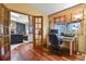 Another office with built-in shelving, wood floors, a window, and an entrance to the living room at 34101 Columbine E Trl, Elizabeth, CO 80107