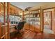 Cozy home office with built-in shelving, wood floors, and a large window for natural light at 34101 Columbine E Trl, Elizabeth, CO 80107