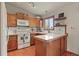 Functional kitchen featuring tile countertops, wood cabinetry, and modern white appliances at 34101 Columbine E Trl, Elizabeth, CO 80107