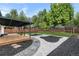 Spacious backyard featuring a covered deck, lush lawn, and elegant landscaping with decorative stones at 6511 S Cedar St, Littleton, CO 80120