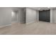 Bright basement area with hardwood floors, recessed lighting, and a modern barn door at 6511 S Cedar St, Littleton, CO 80120