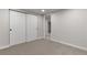 Finished basement featuring neutral walls and carpet with closet and access to another room at 6511 S Cedar St, Littleton, CO 80120