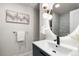 Stylish bathroom features a round lighted mirror, globe sconces, and modern fixtures at 6511 S Cedar St, Littleton, CO 80120