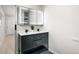 Modern bathroom featuring a double sink vanity with sleek black cabinetry and an illuminated mirror at 6511 S Cedar St, Littleton, CO 80120