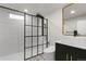 Modern bathroom featuring subway tile, black accents, a glass shower, and unique flooring at 6511 S Cedar St, Littleton, CO 80120