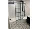 Modern bathroom featuring subway tile, black accents, a glass shower, and unique flooring at 6511 S Cedar St, Littleton, CO 80120