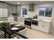 Modern kitchen featuring gray cabinets, stainless steel appliances, and ample counter space with dining area at 6511 S Cedar St, Littleton, CO 80120