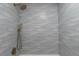 Relaxing walk-in shower featuring wave-patterned tilework, rainfall shower head and handheld sprayer at 6511 S Cedar St, Littleton, CO 80120