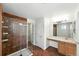 Bathroom featuring a glass shower, a vanity with storage, and tiled floors and walls at 22501 E Belleview Pl, Aurora, CO 80015