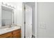 Bathroom featuring a vanity with storage, a mirror, and a door for added privacy at 22501 E Belleview Pl, Aurora, CO 80015