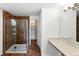 Bathroom with a glass enclosed shower with tiled walls and shelving and a vanity with storage at 22501 E Belleview Pl, Aurora, CO 80015