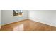 An empty bedroom boasts hardwood floors and a bright window, creating a blank canvas for personalization at 22501 E Belleview Pl, Aurora, CO 80015
