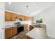 Bright kitchen with wooden cabinets, tile floors, stainless steel appliances, and breakfast bar at 22501 E Belleview Pl, Aurora, CO 80015