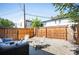Fenced backyard with gravel area, patio, seating, and mature trees; perfect for outdoor enjoyment at 2645 W 24Th Ave, Denver, CO 80211