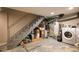 Unfinished basement featuring a staircase, water heater, washer, and dryer at 2645 W 24Th Ave, Denver, CO 80211