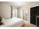 Cozy bedroom featuring a large window, wood floors, neutral colors, and ensuite bathroom at 2645 W 24Th Ave, Denver, CO 80211
