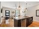 Open-concept kitchen featuring a large island with bar seating and stylish pendant lighting at 2645 W 24Th Ave, Denver, CO 80211