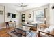 Bright living room features a grey sofa, ceiling fan, modern rug, and hardwood floors at 2645 W 24Th Ave, Denver, CO 80211